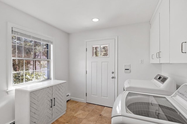 clothes washing area with washer and clothes dryer, a baseboard radiator, cabinet space, baseboard heating, and baseboards