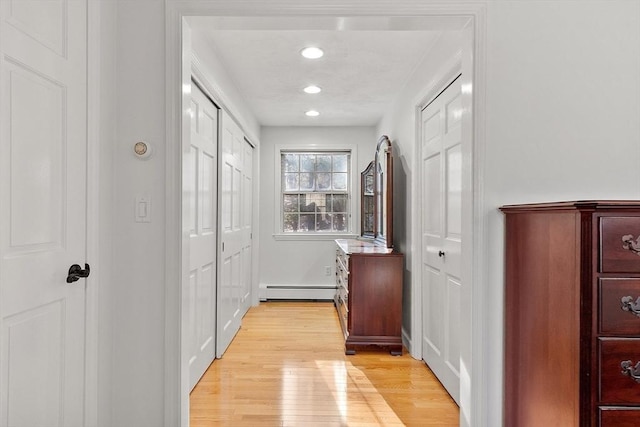 corridor with a baseboard heating unit, recessed lighting, and light wood-style floors