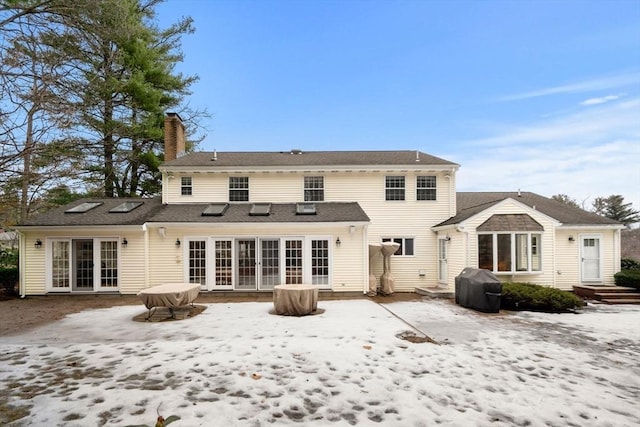 rear view of house featuring french doors and a chimney