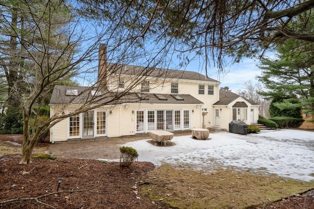 rear view of house featuring french doors, a patio area, and a chimney