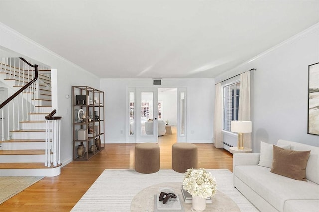 living room featuring crown molding, stairs, visible vents, and wood finished floors