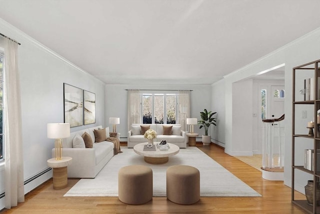 living room featuring a baseboard heating unit, light wood-type flooring, and a healthy amount of sunlight