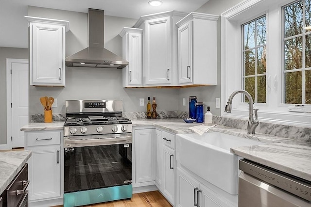 62 Bolton Rd Applewood, Unit Applewood, Westminster, MA 01473 - kitchen featuring stainless steel appliances, wall chimney range hood, white cabinetry, light stone countertops, and recessed lighting
