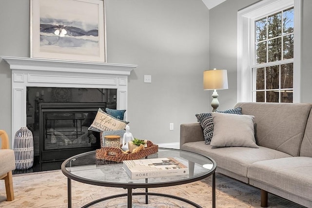 62 Bolton Rd Applewood, Unit Applewood, Westminster, MA 01473 - living area with lofted ceiling, a glass covered fireplace, wood finished floors, and baseboards
