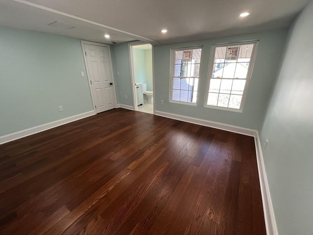 unfurnished room with dark wood-type flooring