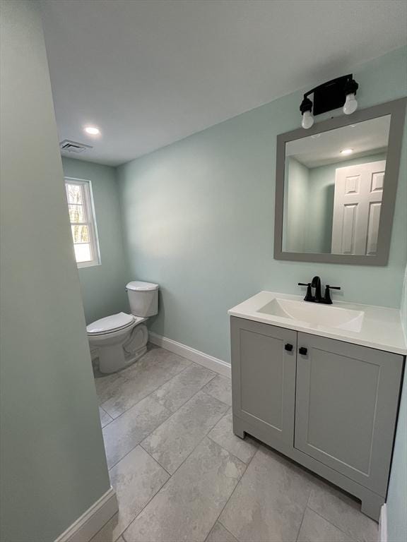 bathroom featuring toilet and vanity