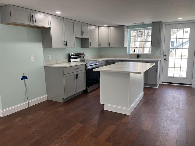 kitchen featuring stainless steel electric stove, sink, dark hardwood / wood-style floors, a kitchen island, and gray cabinetry