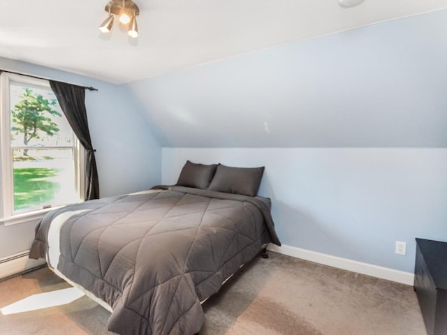 bedroom with a baseboard heating unit, baseboards, carpet, and lofted ceiling