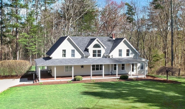 view of front facade with roof with shingles, a porch, and a front lawn
