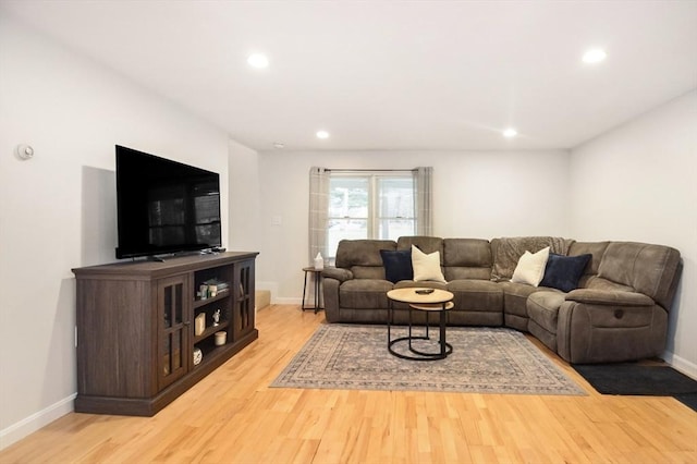 living room with recessed lighting, baseboards, and light wood-style flooring