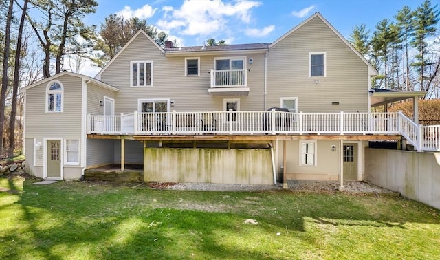 rear view of house with a chimney, a yard, and a deck
