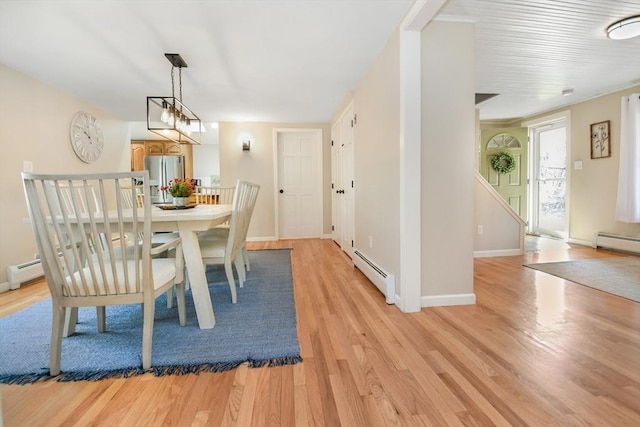 dining area featuring baseboards, baseboard heating, and light wood-style floors