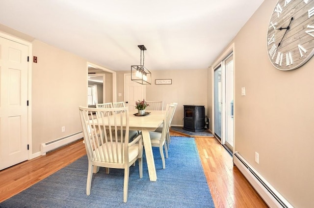 dining room with baseboards, baseboard heating, and light wood finished floors