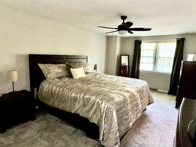 bedroom featuring carpet floors, a ceiling fan, and a textured ceiling