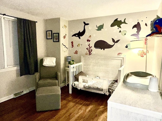 bedroom with wood finished floors and a textured ceiling