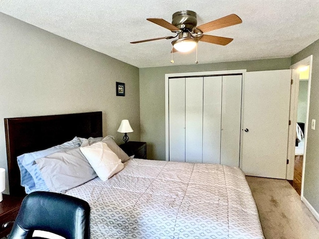 carpeted bedroom featuring a closet, ceiling fan, and a textured ceiling