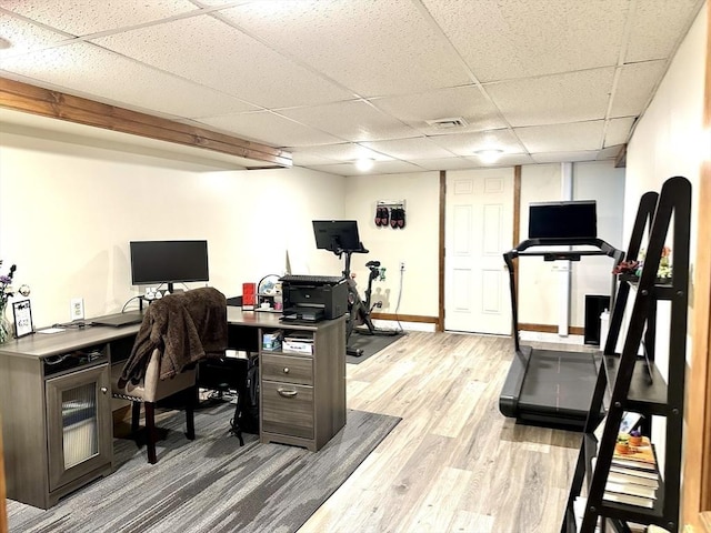 office area with a paneled ceiling, light wood-style floors, and baseboards
