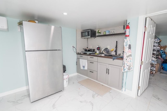 33 Williams St, New London, CT 06320 - kitchen featuring freestanding refrigerator, black microwave, backsplash, light marble finish floors, and white cabinetry