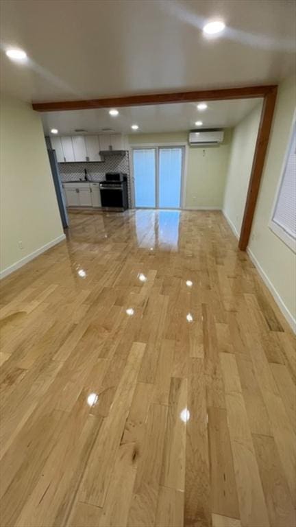 33 Williams St, New London, CT 06320 - unfurnished living room with a wall mounted AC, light wood-type flooring, a fireplace, and recessed lighting