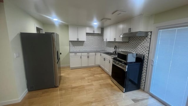 33 Williams St, New London, CT 06320 - kitchen featuring stainless steel appliances, under cabinet range hood, tasteful backsplash, white cabinets, and dark countertops