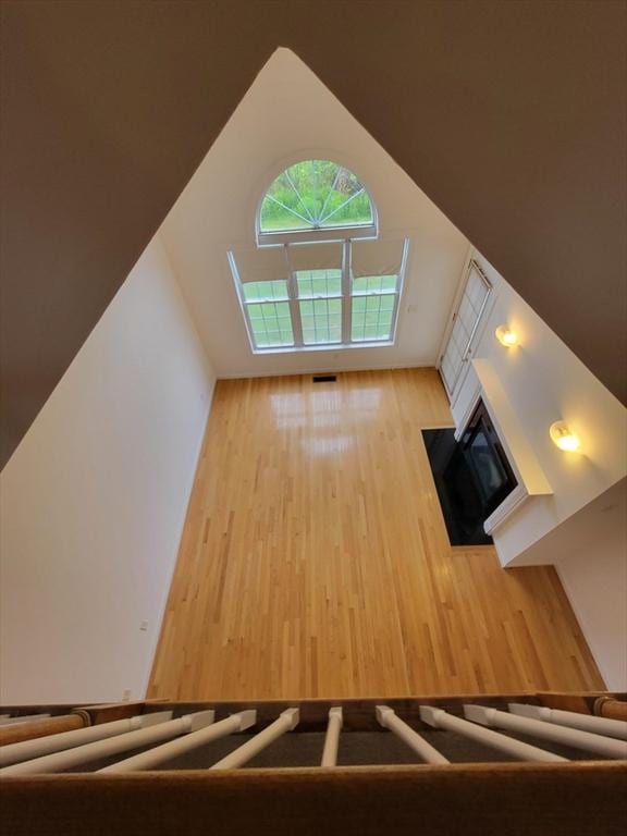 281 Rowley Bridge Rd Unit 7, Topsfield, MA 01983 - unfurnished living room featuring a tiled fireplace, wood finished floors, and lofted ceiling