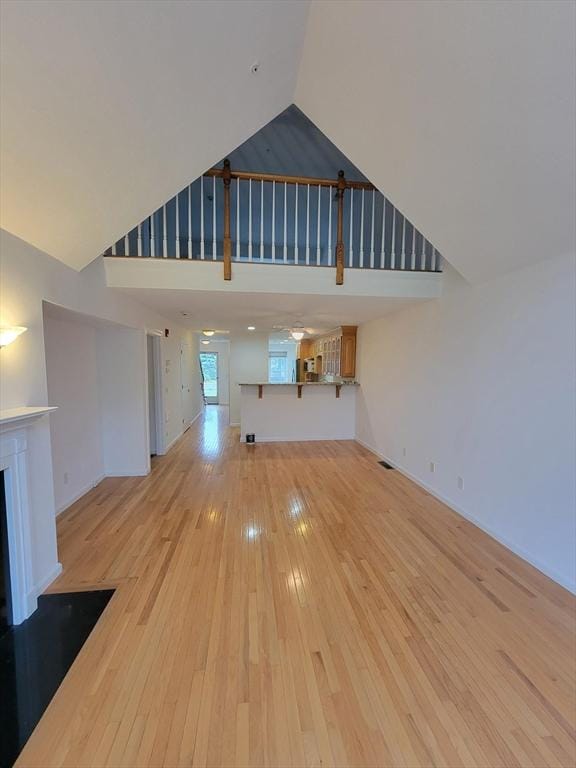 281 Rowley Bridge Rd Unit 7, Topsfield, MA 01983 - unfurnished living room featuring high vaulted ceiling, light wood finished floors, and a fireplace