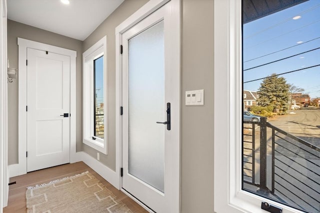 doorway to outside featuring light wood finished floors and baseboards