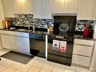 40 Village Rd Unit 606, Middleton, MA 01949 - kitchen featuring black appliances, dark countertops, backsplash, and light tile patterned flooring