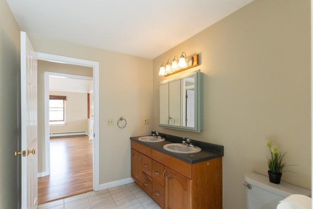 135 Main St, Blackstone, MA 01504 - bathroom featuring a baseboard heating unit, double vanity, and tile patterned floors