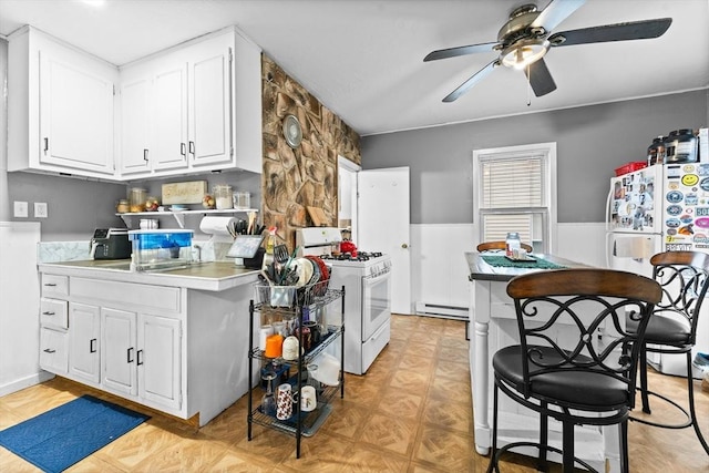 kitchen with ceiling fan, white cabinets, white appliances, and baseboard heating