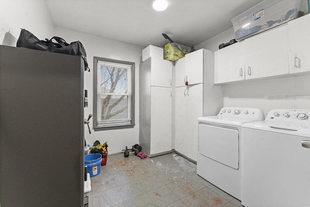 laundry room with separate washer and dryer and cabinets