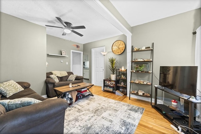 living room featuring hardwood / wood-style floors, beamed ceiling, and ceiling fan