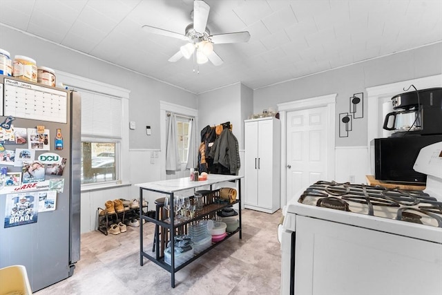 kitchen featuring white range with gas cooktop, stainless steel fridge, and ceiling fan