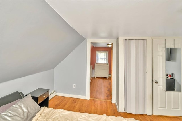 120 E Ashland St, Brockton, MA 02302 - bedroom featuring wood finished floors, baseboards, a baseboard heating unit, multiple closets, and lofted ceiling