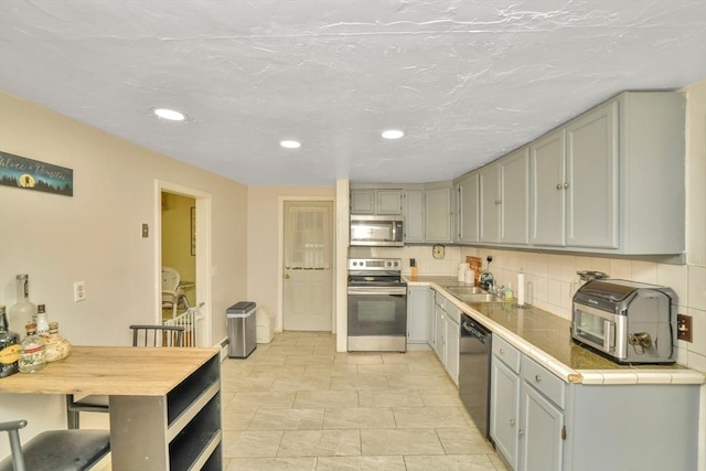 120 E Ashland St, Brockton, MA 02302 - kitchen featuring stainless steel appliances, recessed lighting, gray cabinetry, decorative backsplash, and a sink