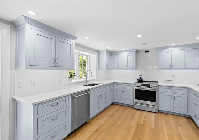 1164 Main St, Hingham, MA 02043 - kitchen with a sink, stainless steel appliances, light wood-style floors, backsplash, and light countertops