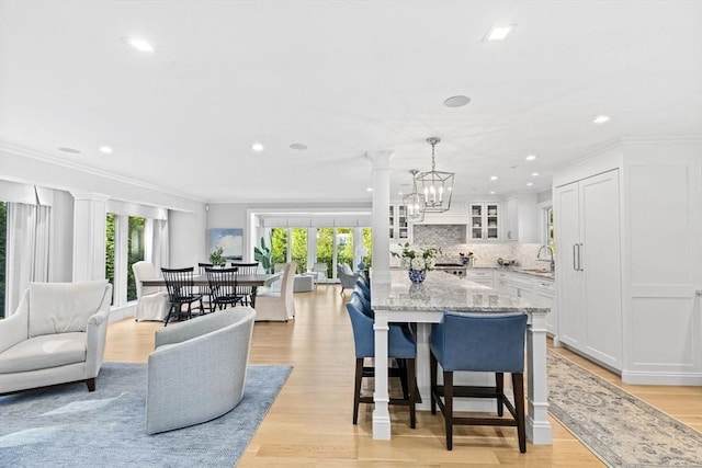 1164 Main St, Hingham, MA 02043 - kitchen featuring open floor plan, glass insert cabinets, white cabinets, light stone counters, and recessed lighting