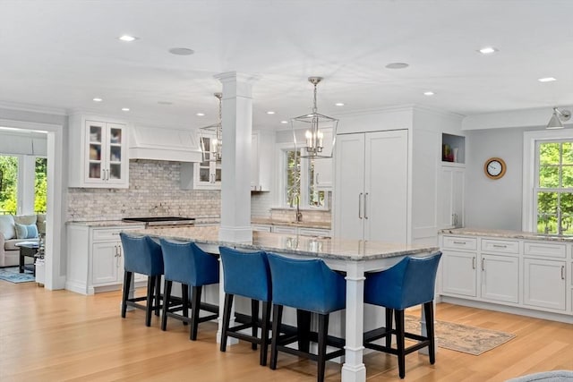 1164 Main St, Hingham, MA 02043 - kitchen with decorative columns, white cabinetry, decorative backsplash, recessed lighting, and crown molding
