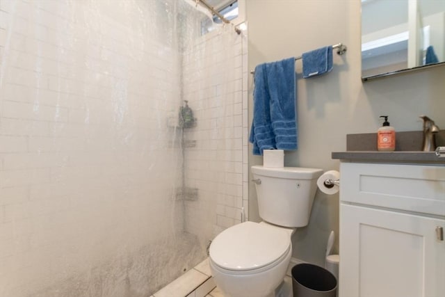 bathroom with vanity, toilet, and tiled shower