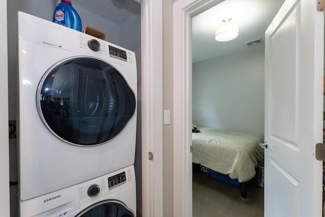 laundry room with stacked washer and clothes dryer and carpet floors