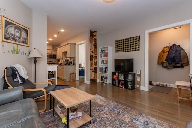 living room featuring dark wood-style flooring, baseboards, and recessed lighting