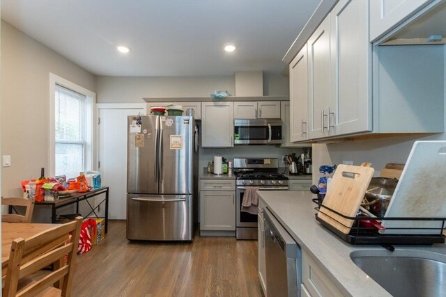 kitchen featuring stainless steel appliances, dark wood-type flooring, light countertops, recessed lighting, and gray cabinets