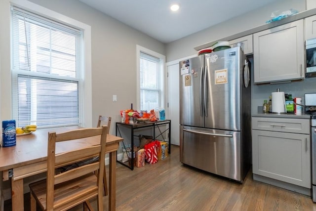 kitchen with stainless steel appliances, light wood finished floors, gray cabinets, and recessed lighting