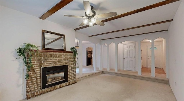 33 Cobblestone Ln Unit 33, Worcester, MA 01606 - unfurnished living room featuring arched walkways, beamed ceiling, a fireplace, and a ceiling fan