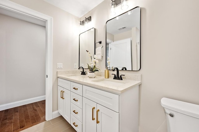 59A Mount Ave, Worcester, MA 01606 - full bathroom featuring double vanity, toilet, baseboards, and wood finished floors