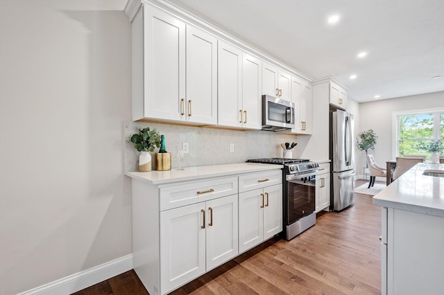 59A Mount Ave, Worcester, MA 01606 - kitchen featuring appliances with stainless steel finishes, light wood-style floors, backsplash, light countertops, and white cabinets