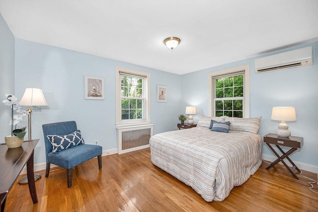 15 Eustis Ave, Wakefield, MA 01880 - bedroom with a wall mounted AC, radiator, multiple windows, and wood finished floors
