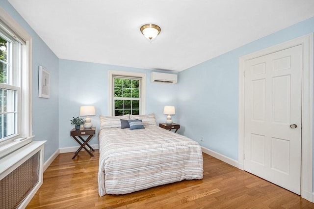 15 Eustis Ave, Wakefield, MA 01880 - bedroom with a wall mounted air conditioner, wood finished floors, baseboards, and radiator heating unit