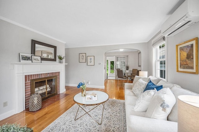 15 Eustis Ave, Wakefield, MA 01880 - living area with a wall mounted air conditioner, arched walkways, wood finished floors, a fireplace, and ornamental molding