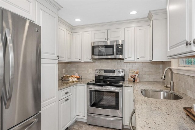 15 Eustis Ave, Wakefield, MA 01880 - kitchen featuring appliances with stainless steel finishes, a sink, white cabinetry, and tasteful backsplash